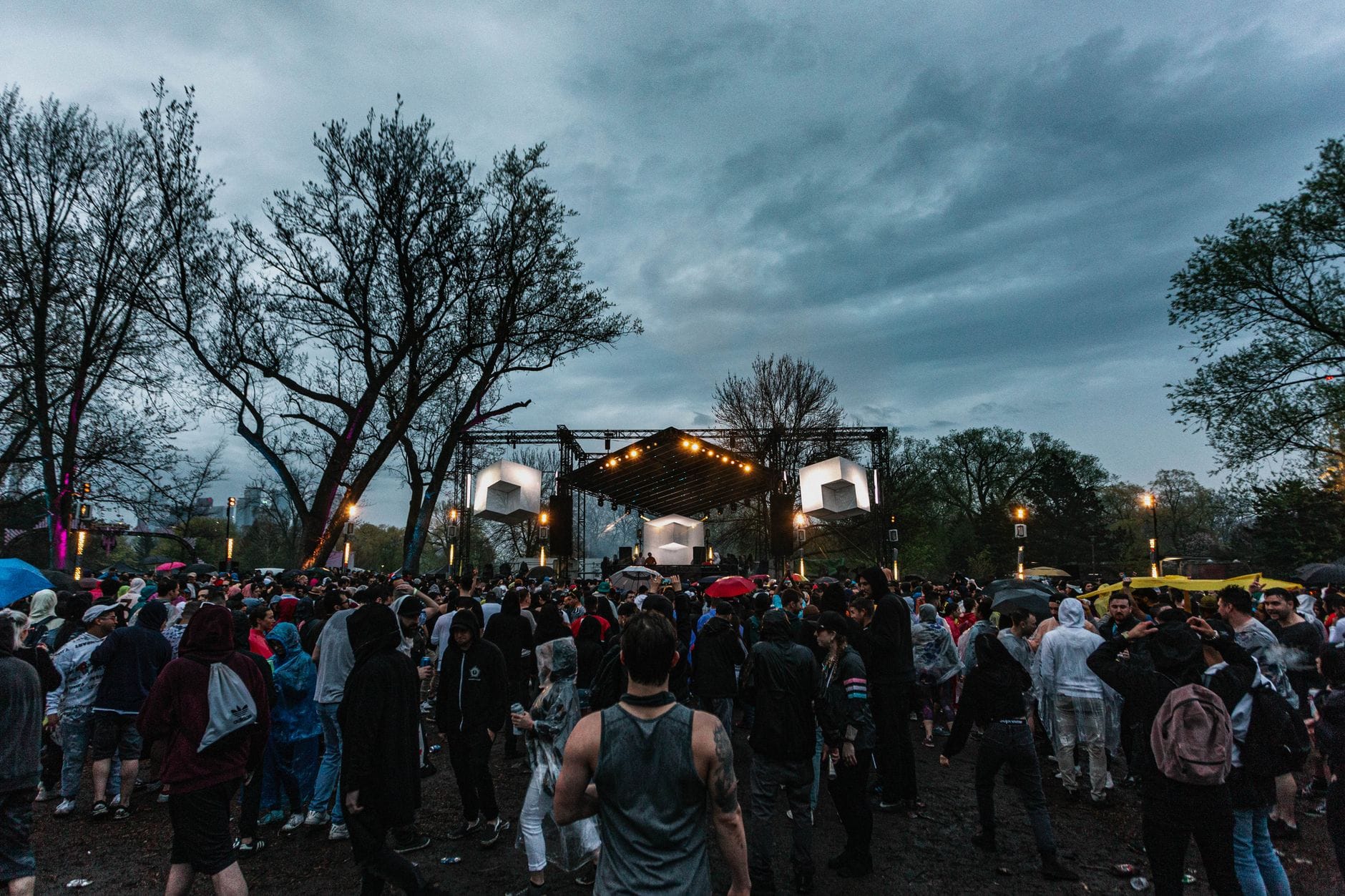 Tłum wokół sceny na plenerowym festiwalu pod burzowymi chmurami